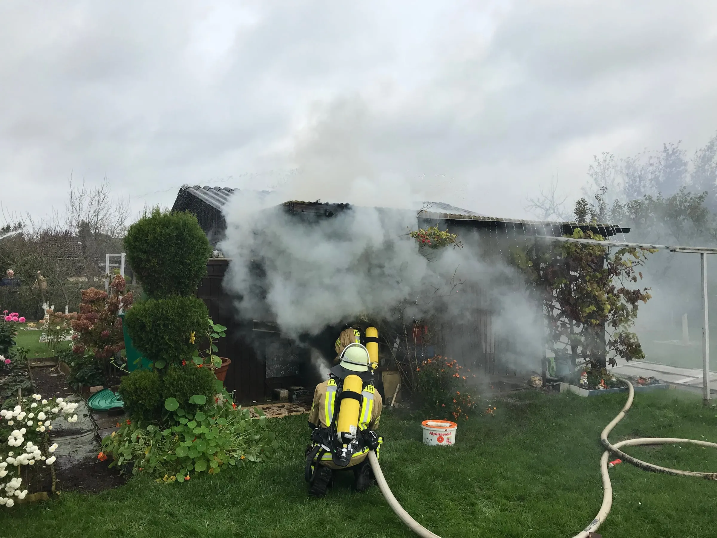 Brand einer Gartenlaube: Atemschutzgeräteträger beim Löschen