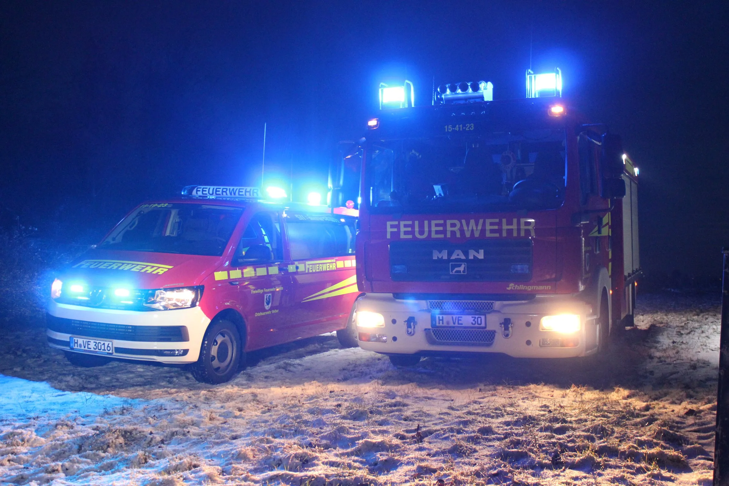 TSF-W und Mannschaftstransportfahrzeug mit Blaulicht bei Nacht