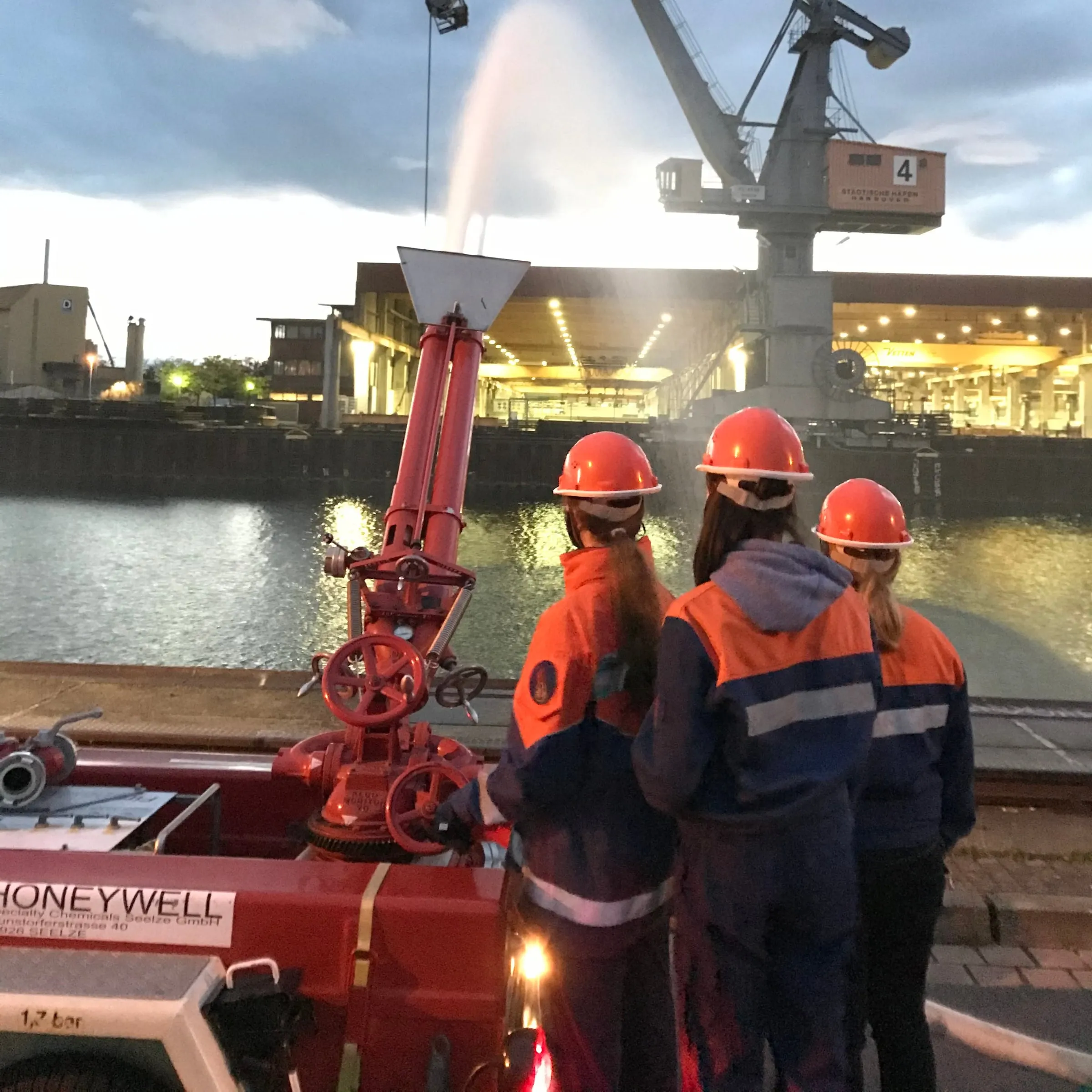 Drei Jugendliche am Schaum-Wasser-Werfer am Hafen