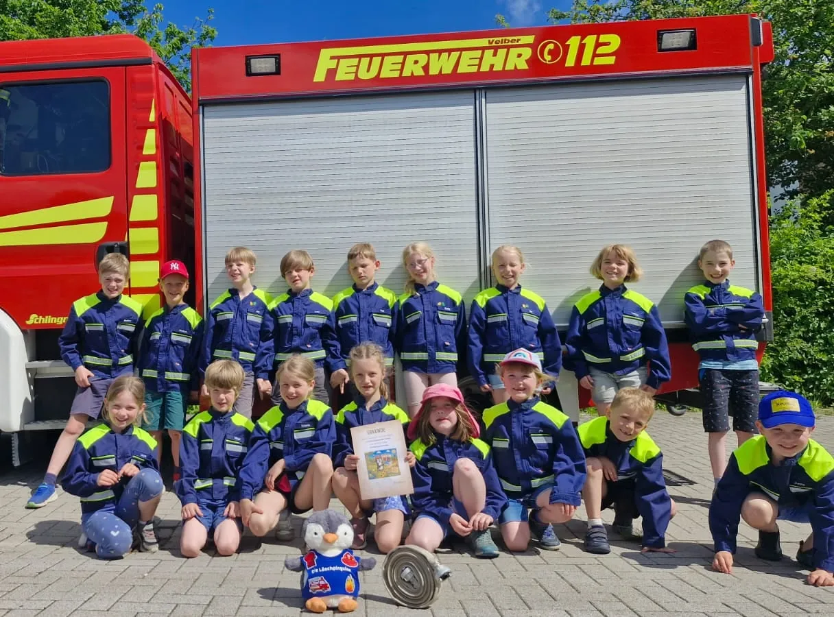 Die Kinder der Kinderfeuerwehr vor dem TSF-W mit dem Maskottchen Löschi
